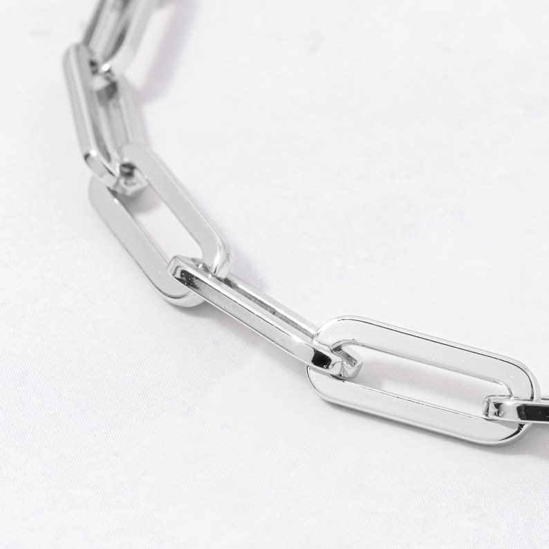 May include: A silver chain necklace with large, oval-shaped links.