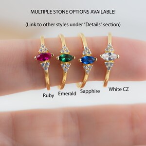 K&ouml;nnte beinhalten: Vier goldene Ringe mit verschiedenen Edelsteinen. Die Ringe haben einen markisenf&ouml;rmigen Edelstein, der von kleineren runden Steinen umgeben ist. Die Edelsteine sind Rubin, Smaragd, Saphir und wei&szlig;er Zirkonia.