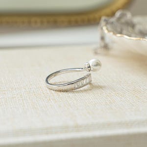 side closeup view of  sterling silver baguette ring with wrap ring design