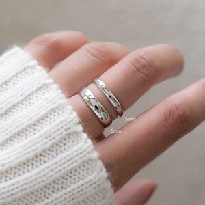 model wearing dainty rings and showing comparison of thin and thick silver rings for stacking inspiration.