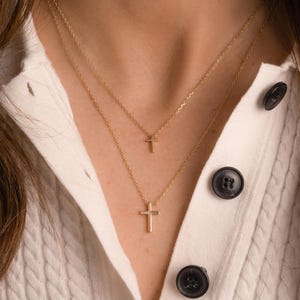 Model wearing dainty plain gold cross necklaces