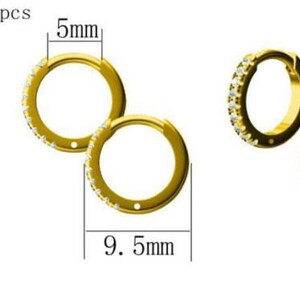 Puede incluir: Un par de pendientes de aro de oro con una fila de peque&ntilde;as piedras de circonita c&uacute;bica transparentes alrededor del aro. Los pendientes tienen un di&aacute;metro de 9,5 mm y un ancho de 5 mm.  cz: 1 mm x 18pcs