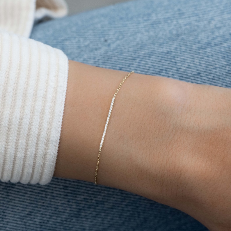 May include: A delicate gold chain bracelet with a thin row of small diamonds.