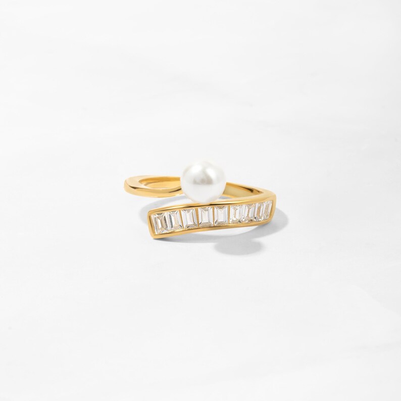 14k gold plated ring featuring a gold wrap design, accented with freshwater pearls and baguette-cut diamonds