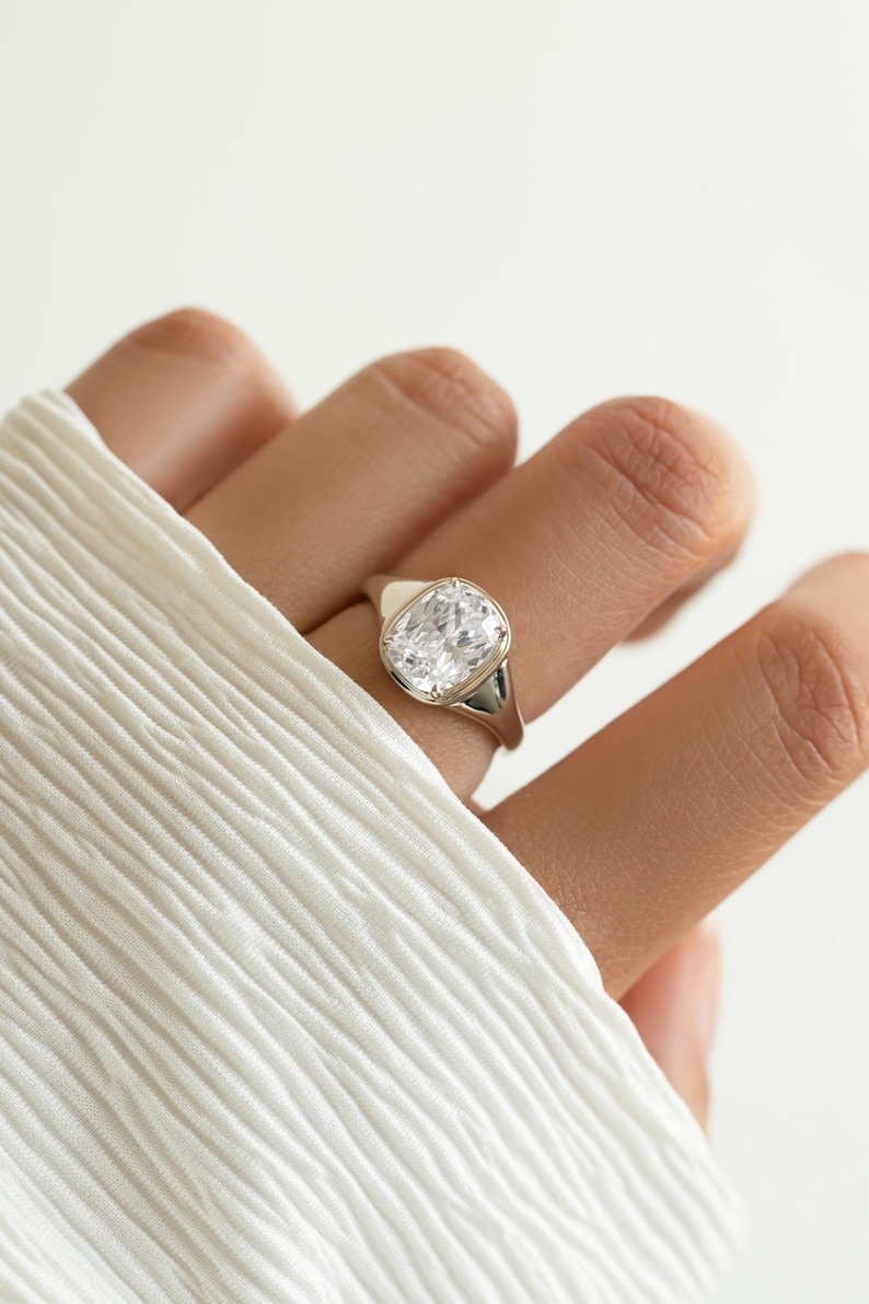 Elongated cushion cut ring in sterling silver, shown worn on the hand with a bezel setting for a vintage-inspired statement look
