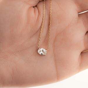 model holding oval solitaire diamond necklace