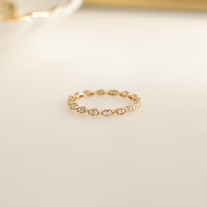 Closeup image of gold stacking ring with pave diamonds