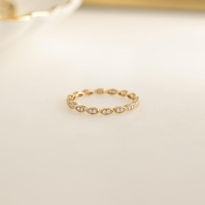 Closeup image of gold stacking ring with pave diamonds