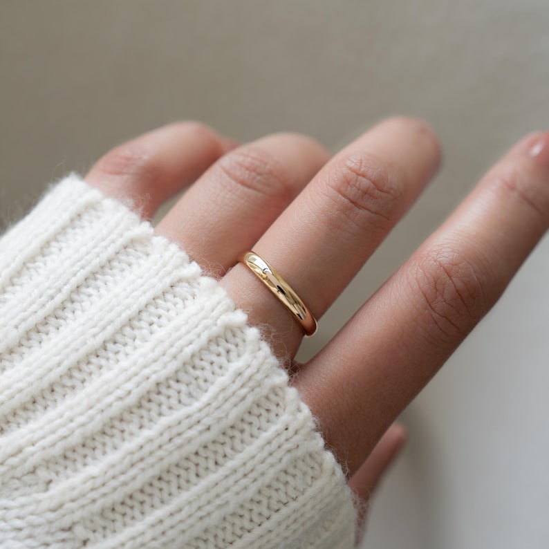 a model wearing a dainty, simple gold band