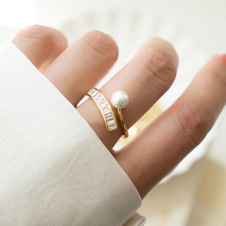 model wearing gold baguette ring featuring a spiral ring design and a freshwater pearl