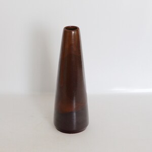 Könnte beinhalten: Eine braune Keramikvase mit konischer Form.