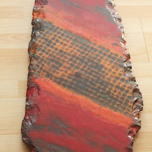 May include: A red, orange, and black ceramic serving tray with an irregular shape and a textured surface.
