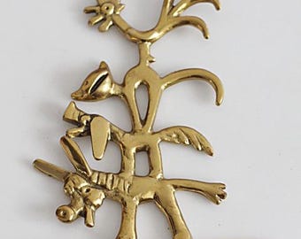 May include: A brass key holder for wall mounting, with a quirky design of animals stacked on top of each other: a rooster, a cat, a dog, and a donkey. It has four hooks for keys or small items. The brass has a warm, golden colour.