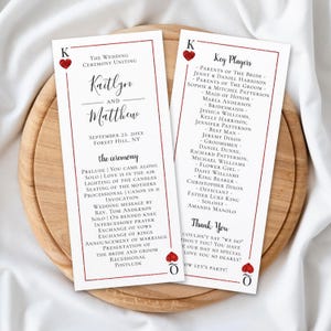 May include: Two rectangular wedding ceremony programs designed like playing cards with red glitter heart accents. The text includes the names Kaitlyn and Matthew, the date September 22, 20XX, the ceremony order, a list of key players, and a thank you note.