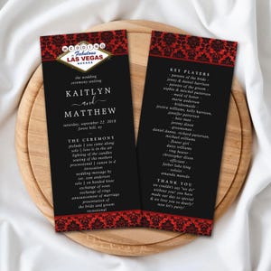 May include: Two black and red wedding program cards featuring a Las Vegas sign graphic. The text includes the names Kaitlyn and Matthew, the date September 22, 2018, ceremony details, and a list of key players including parents, bridal party, and officiant.