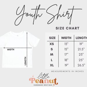 May include: Youth shirt size chart with measurements in inches. XS: 13" wide, 19" long. S: 15" wide, 21.5" long. M: 17" wide, 23" long. L: 18" wide, 25" long. XL: 19" wide, 26.5" long.