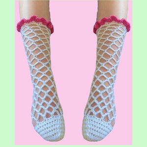 May include: A pair of white crocheted socks with pink ruffled tops. The socks are made with a fishnet pattern.