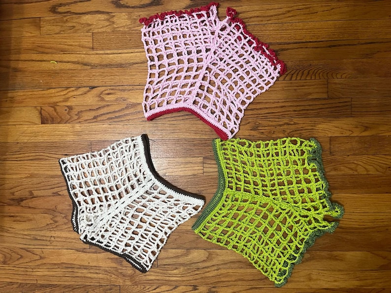 May include: Three crocheted tops in different colors: pink, white, and green. Each top has a unique pattern and is made with a fine, delicate yarn.