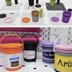 May include: A selection of small, brightly coloured bucket-shaped containers. One is orange and white with a label saying "Ms. Avalyn" and "You're the Glue THAT KEEPS THIS CLASS TOGETHER." Another is black with "COMPOSITION BOOK Mr. Austin" on it.