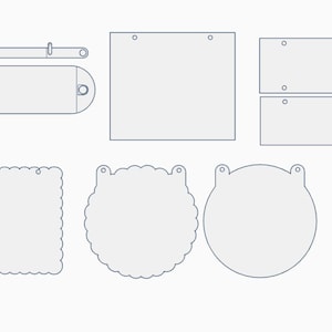 May include: A collection of light gray flat shapes with dark outlines, including rectangular, square, circular, and scalloped-edge plaques with pre-cut holes for hanging, plus two small circular rings, all arranged on a plain white background.