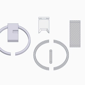 May include: A collection of 3D-rendered, light gray objects. The objects include two incomplete circles, a rectangular block with a curved top, a small rectangular piece, and a long, thin rectangular piece with diagonal lines.