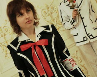 May include: Two people dressed in cosplay costumes. The person on the left is wearing a black and white striped uniform with a red bow. The person on the right is wearing a white uniform with black trim and a red rose.