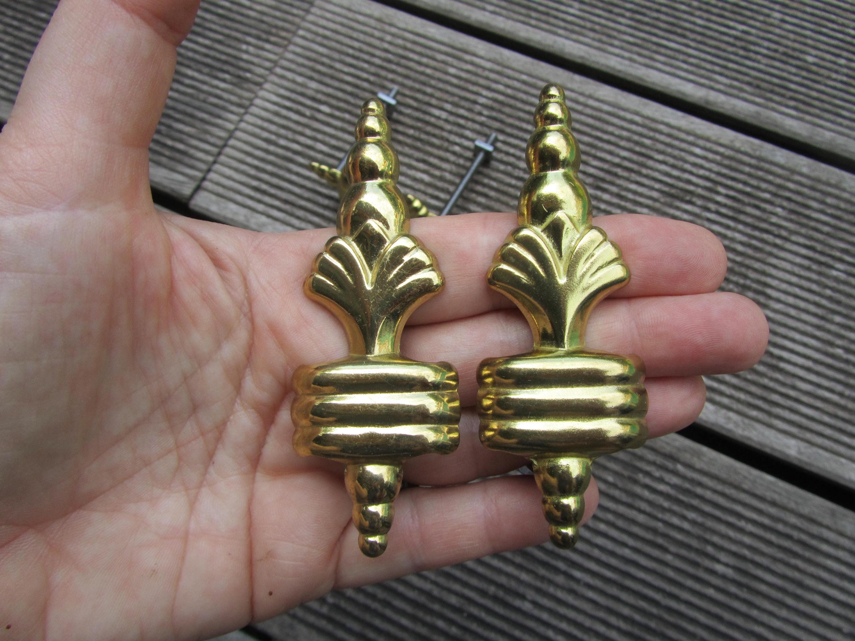 Pair of furniture handles or brass friezes.