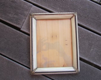 May include: A rectangular picture frame with a gold and white border. The frame is empty and has a light brown wooden backing.