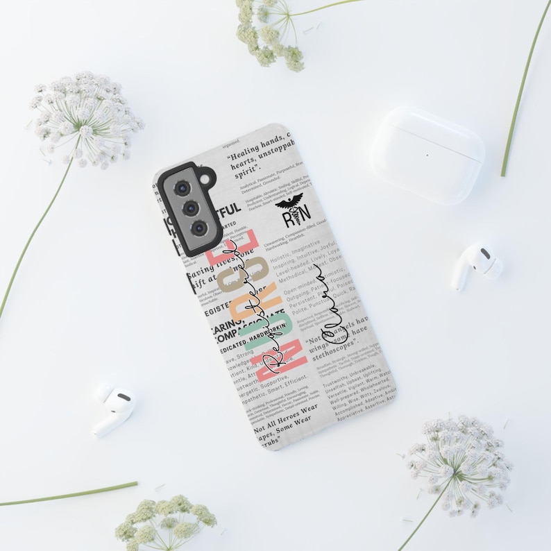 May include: A white phone case with a newspaper-style design featuring the words "Remarkable" and "Not All Heroes Wear Capes, Some Wear Scrubs". The case also includes a black and white image of a caduceus, a symbol associated with medicine, and the letters "RN".