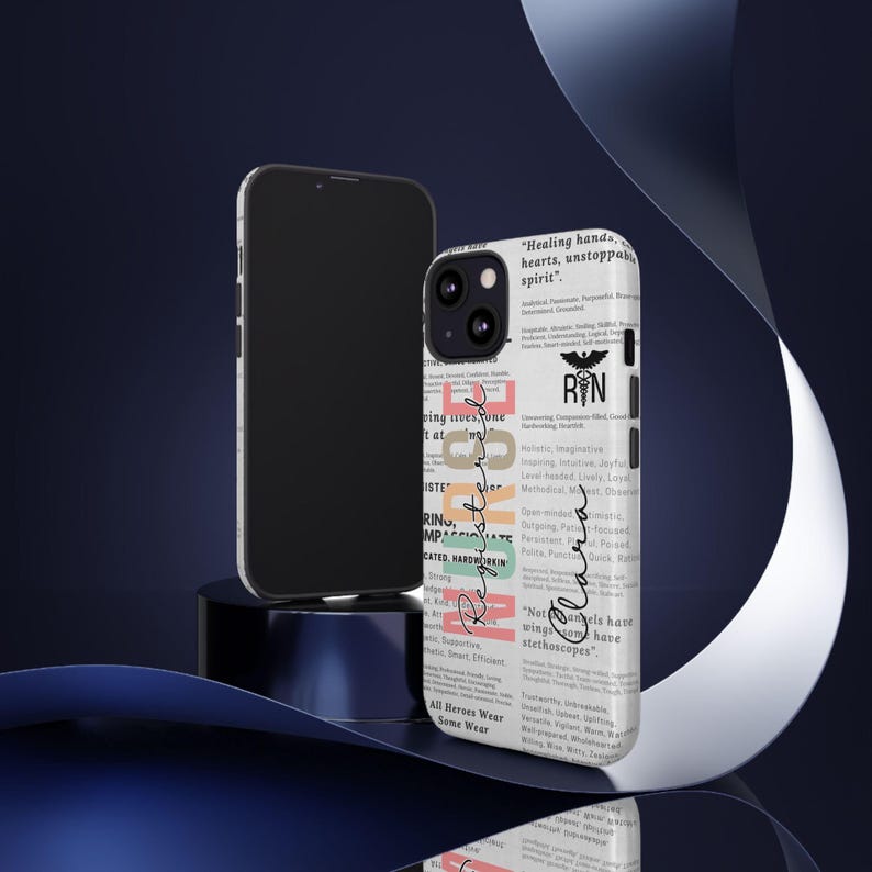 May include: A white iPhone case with a colorful design featuring the word "Registered Nurse" and a list of positive adjectives describing the profession. The case also includes the text "Healing hands, hearts, unstoppable spirit" and "Not all angels have wings, some have stethoscopes".