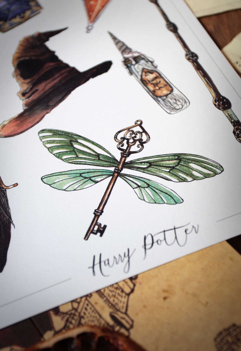 Op de afbeelding: Een gouden sleutel met groene libellenvleugels. De sleutel bevindt zich op een witte achtergrond met de tekst "Harry Potter" in zwarte cursieve letters.