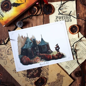 May include: A watercolour illustration of Hagrid's Hut from the Harry Potter series. The hut is depicted with a green roof and brown walls, surrounded by pumpkins and autumn leaves. The text "Hagrid's Hut" is written in cursive at the bottom of the illustration.