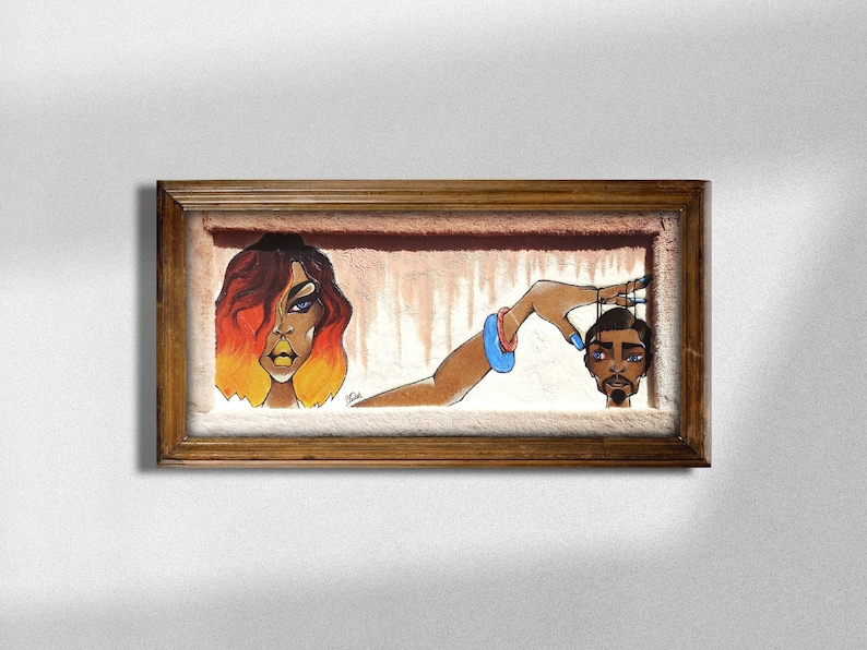 May include: A framed painting depicting a woman with red and orange hair holding a string attached to a man's head. The woman has blue eyes and yellow eyeshadow. The man has a beard and blue nail polish.