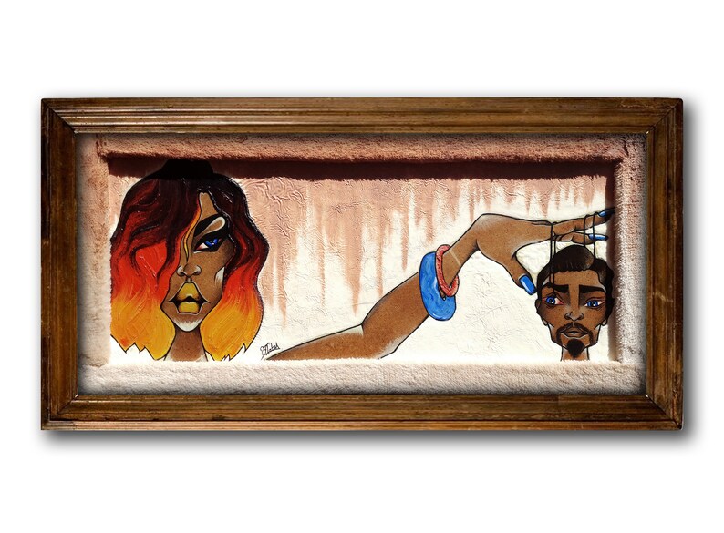 May include: A framed painting featuring a woman with red and orange hair holding a string attached to a man's head. The woman has blue eyes and is wearing a blue bracelet. The man has a beard and is looking at the viewer. The background is a light brown colour.