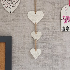 White clay hanging trio of hearts with peacock henna style design on natural twine. Wall hanging. Heart wall. Gift. Valentine's. Decoration. image 1