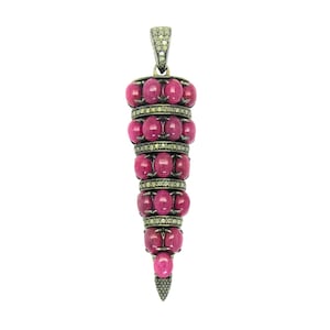 May include: A pendant with a tapered design, featuring alternating rows of oval-shaped, deep pink gemstones and bands of smaller, sparkling stones. The top and bottom of the pendant are also adorned with smaller stones, and it has a loop for a chain.