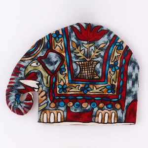 Könnte beinhalten: Ein farbenfroher bestickter Tee-Wärmer in Form eines Elefanten. Der Elefant ist rot, blau, grün und gelb mit einem floralen Muster. Der Wärmer ist aus Stoff und hat einen langen Rüssel.