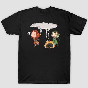 Puede incluir: Camiseta negra con una ilustración de dibujos animados de dos personajes. Un personaje es una mujer con cabello rojo y el otro es una criatura de piel verde con orejas puntiagudas. La mujer sostiene un objeto pequeño y la criatura mira hacia arriba a una nube con lluvia cayendo de ella.