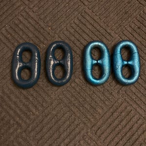 May include: Four blue metal chain links, two on each side, with a shiny, almost iridescent finish.