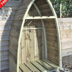 May include: A wooden log store with an arched roof and slatted floor. The structure is made from light-coloured wood and includes a shelf. The text "DELIVERED FULLY ASSEMBLED" is visible. The shed is fully assembled.