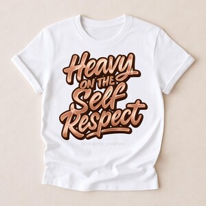 Puede incluir: Camiseta blanca con la frase "Heavy on the Self Respect" en fuente marr&oacute;n con efecto met&aacute;lico y sombra. La camiseta tiene las mangas enrolladas. El @cricketts_creations est&aacute; en la parte inferior.