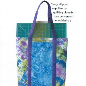May include: A purple and blue tote bag with a tie-dye pattern. The bag has two long straps and is large enough to hold a cutting mat. The text "Totally Awesome Toolbag" and "#FLF 103" is at the top of the image. The text "For the Love of Fabric" and "www.lovethefabric.com" is at the bottom of the image.