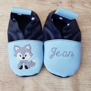 May include: A pair of blue baby shoes with a fox embroidered on one shoe and the name "Jean" embroidered on the other shoe.