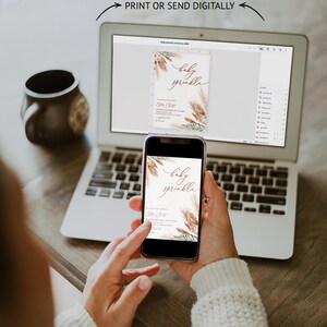 K&ouml;nnte beinhalten: Ein Laptop und ein Smartphone zeigen ein Baby-Sprinkle-Einladungsdesign. Die Einladung zeigt elegante Schrift und botanische Illustrationen in Braun- und Gr&uuml;nt&ouml;nen. Der Text "MOBILE OR DESKTOP PRINT OR SEND DIGITALLY" ist sichtbar.