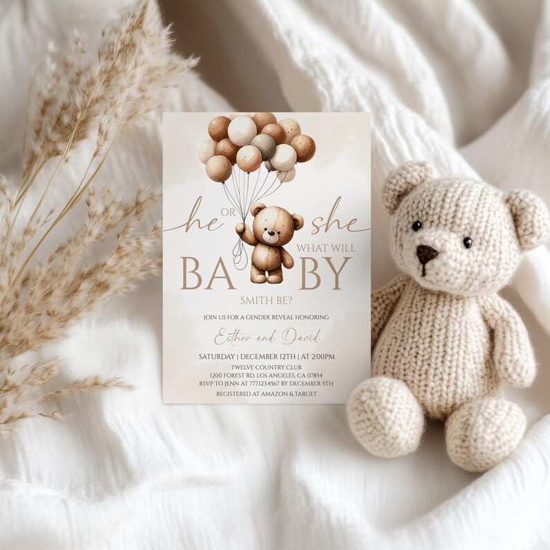 May include: A baby gender reveal invitation with a teddy bear holding balloons. The text reads "He or She, What Will Baby Smith Be?" A knitted teddy bear sits next to the invitation. The invitation includes event details.