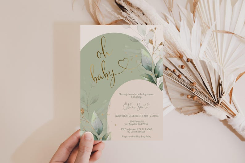 Op de afbeelding: Een rechthoekige uitnodigingskaart voor een babyshower met een saliegroene boog, een beige achtergrond en goudkleurige tekst die oh baby leest. Het ontwerp bevat aquarel eucalyptusbladeren en gouden accenten met details in zwarte inkt.