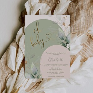 Op de afbeelding: Een rechthoekige uitnodigingskaart voor een babyshower met een saliegroene boog, een zachtroze halve cirkel en aquarel eucalyptusbladeren. De tekst luidt: oh baby, Please join us for a baby shower honoring Esther Smith, ZATERDAG | 12 DECEMBER | 14:00 UUR.