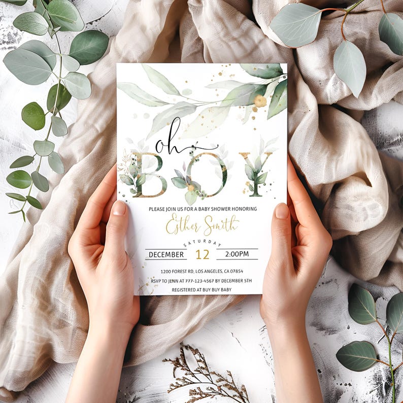 May include: A baby shower invitation with the words "Oh Boy" in elegant script and floral accents. The invitation includes details for the event, such as the date, time, and location, and is held by a person.