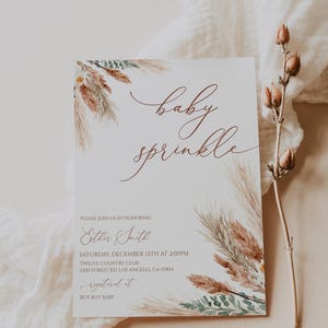 K&ouml;nnte beinhalten: Eine Baby-Sprinkle-Einladung mit der Aufschrift "baby sprinkle" in eleganter Kalligraphie. Die Einladung zeigt Aquarellillustrationen von getrockneten Gr&auml;sern und Gr&uuml;nzeug. Der Text enth&auml;lt Datum, Uhrzeit und Ort der Veranstaltung.