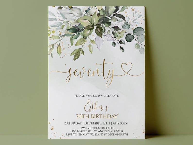 May include: A rectangular invitation card featuring a watercolor illustration of green eucalyptus leaves and gold flecks at the top. The text reads: seventy, PLEASE JOIN US TO CELEBRATE, Esther's, 70TH BIRTHDAY, SATURDAY | DECEMBER 12TH | AT 2:00PM, TWELVE COUNTRY CLUB, 1200 FOREST RD. LOS ANGELES, CA 07854, RSVP TO JENN AT 777.123.4567BY DECEMBER 5TH.